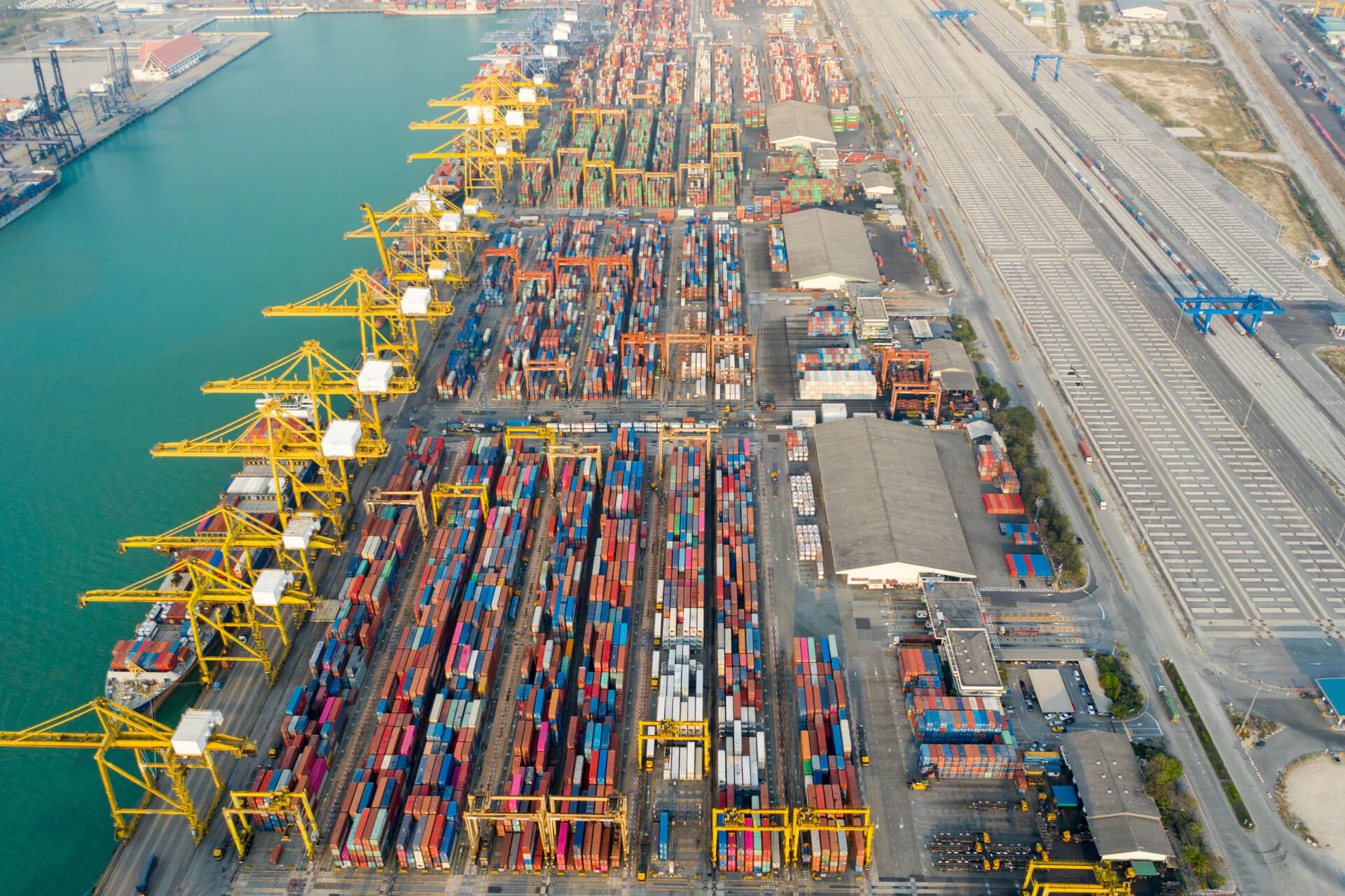 Aerial view. Container ship in pier with crane bridge carries out export and import business in the sea.